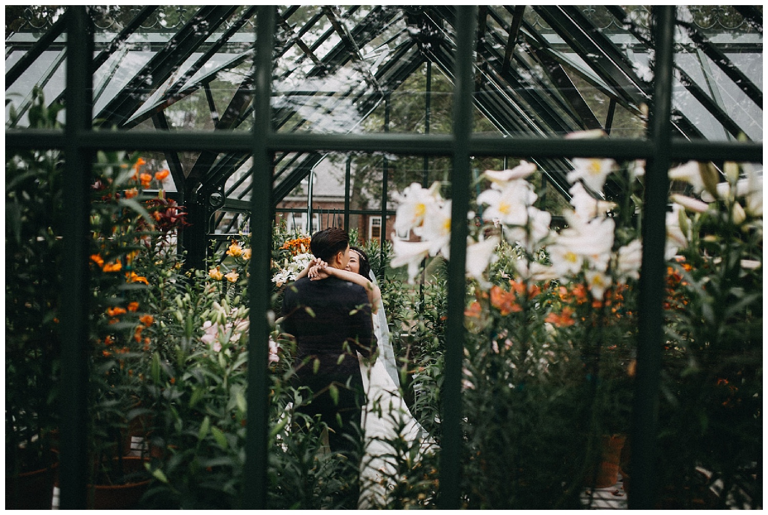 bride and groom embracing in elm bank greenhouse