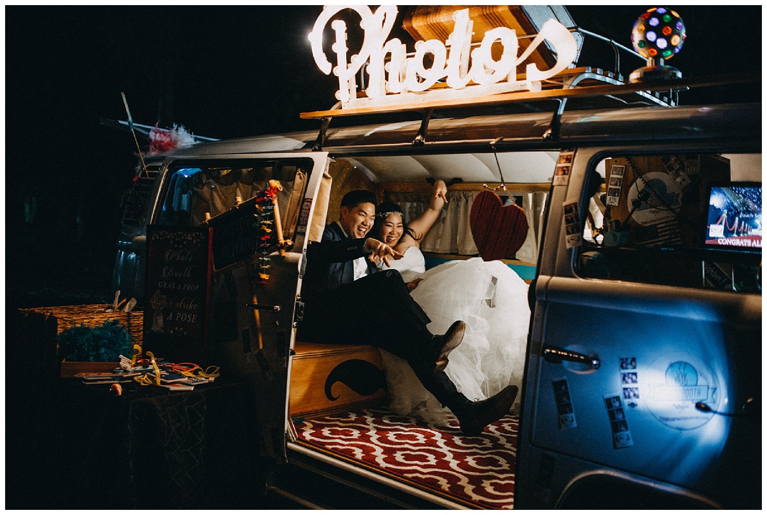 bride and groom have fun in VW bus photobooth