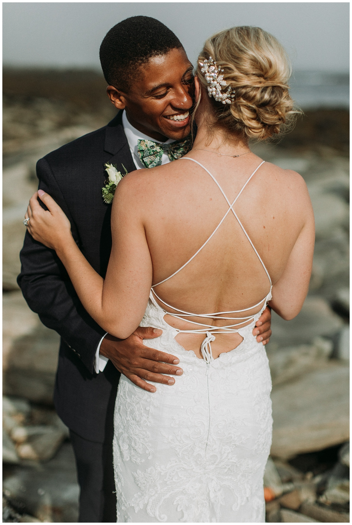 a groom embracing his bride on the beach