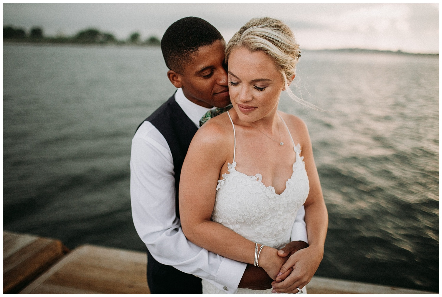 a bride and groom embrace on a dock on Peaks Island