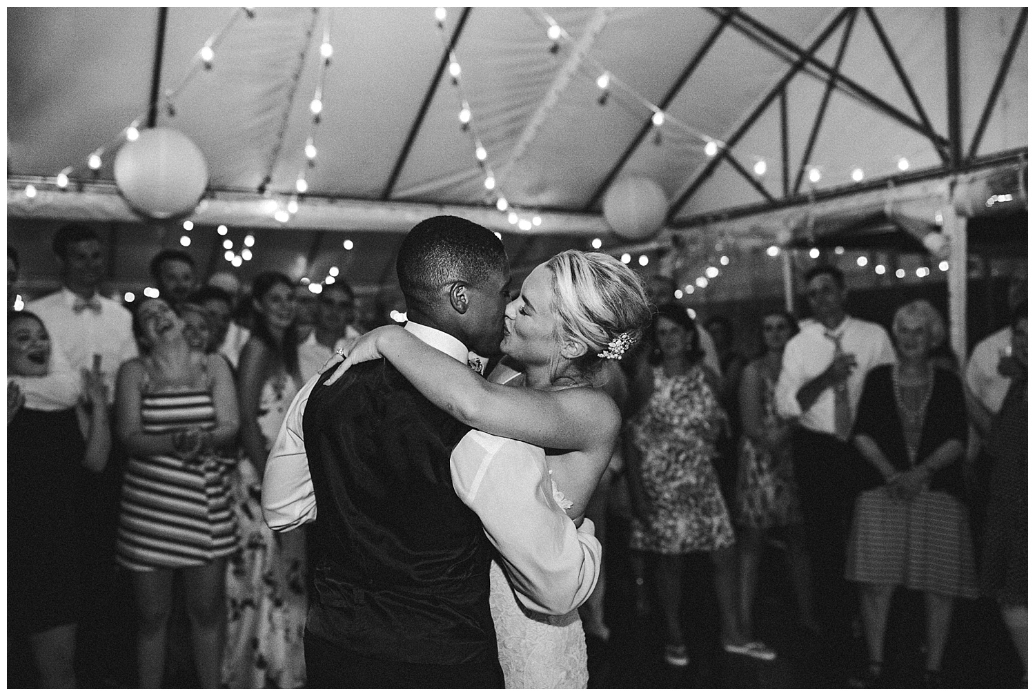 a couple kisses at the end of their wedding reception