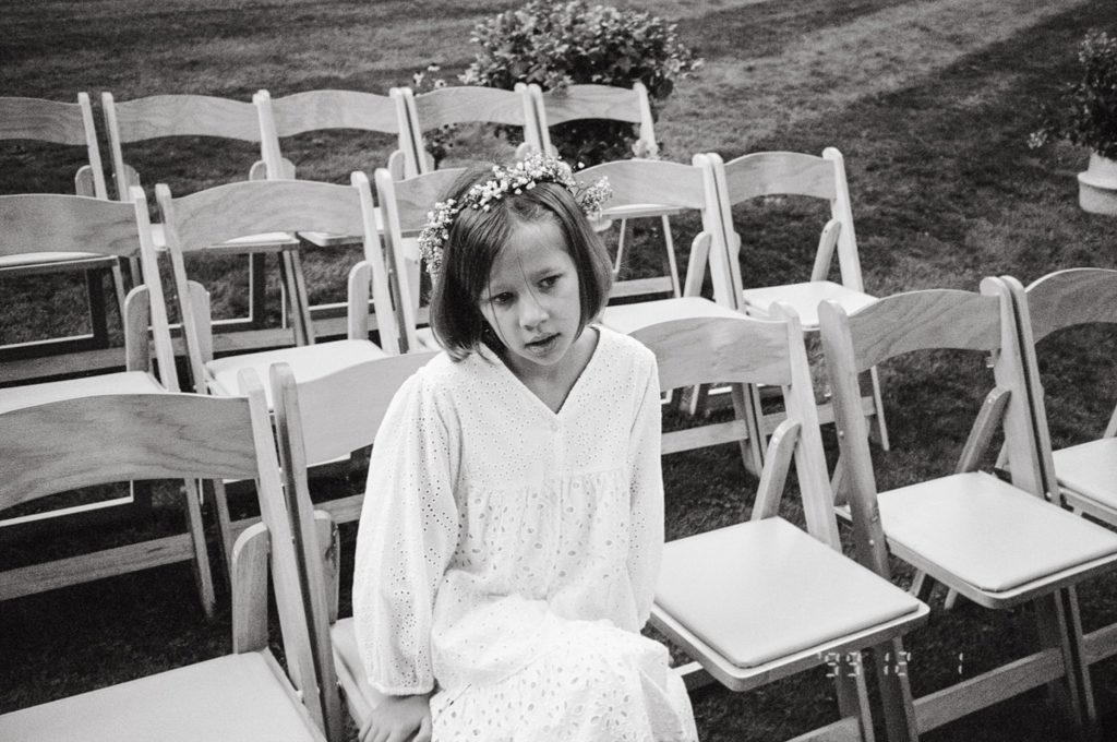 a flower girl sits before the wedding
