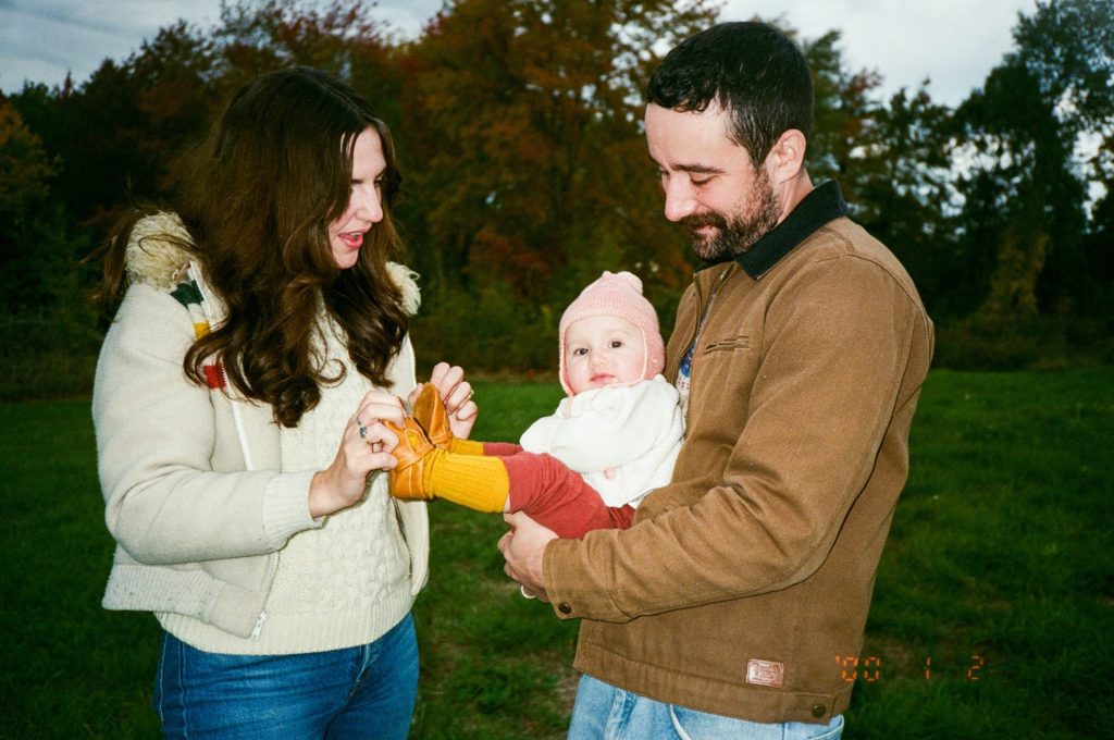 parents look lovingly at their daughter during a fall family portrait session