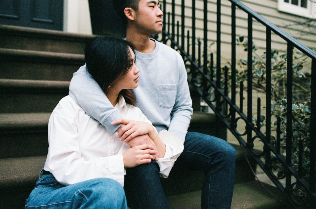 Couple sits together on stoop in Brooklyn