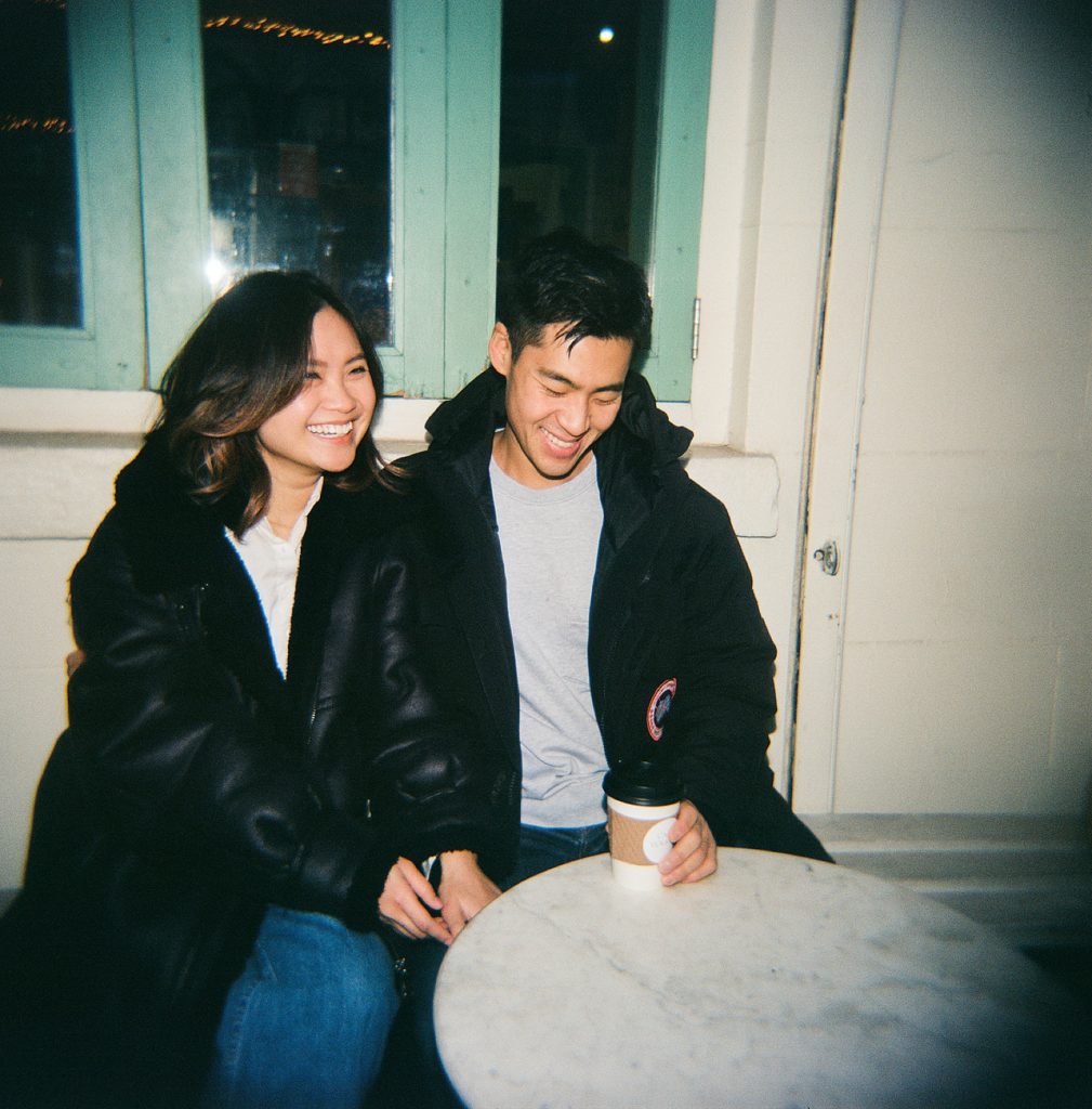 Laughing couple seated at Brooklyn coffeeshop