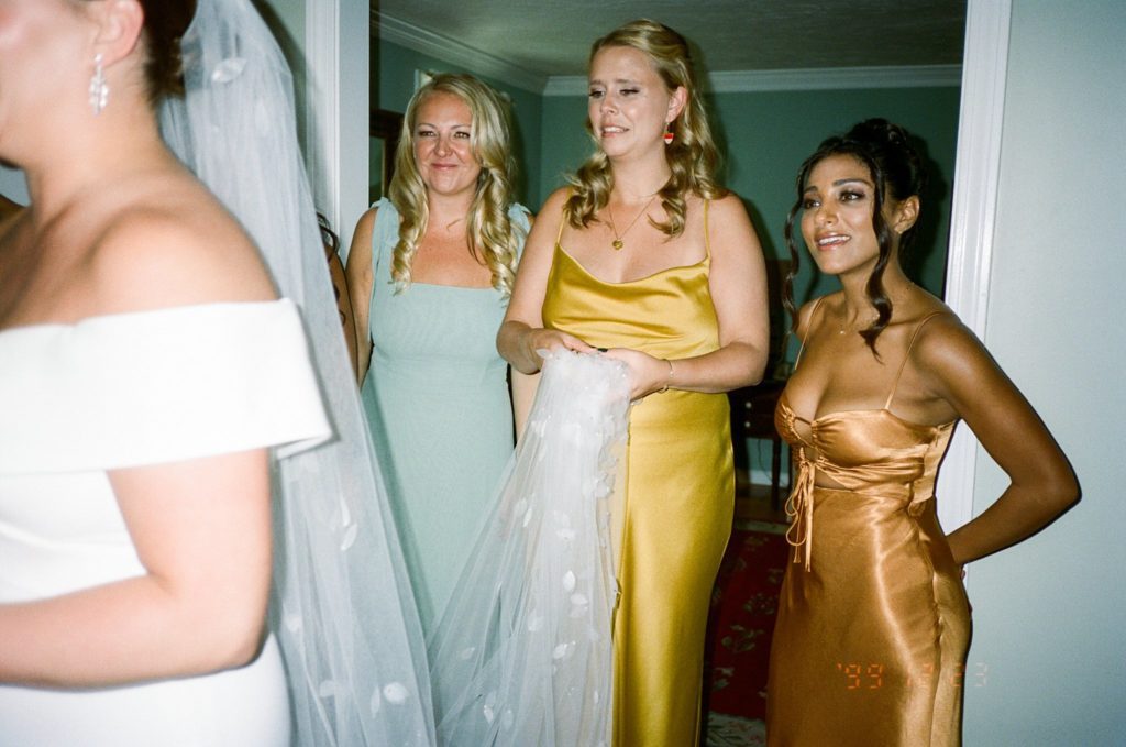 Bridesmaids look at bride emotionally captured on film
