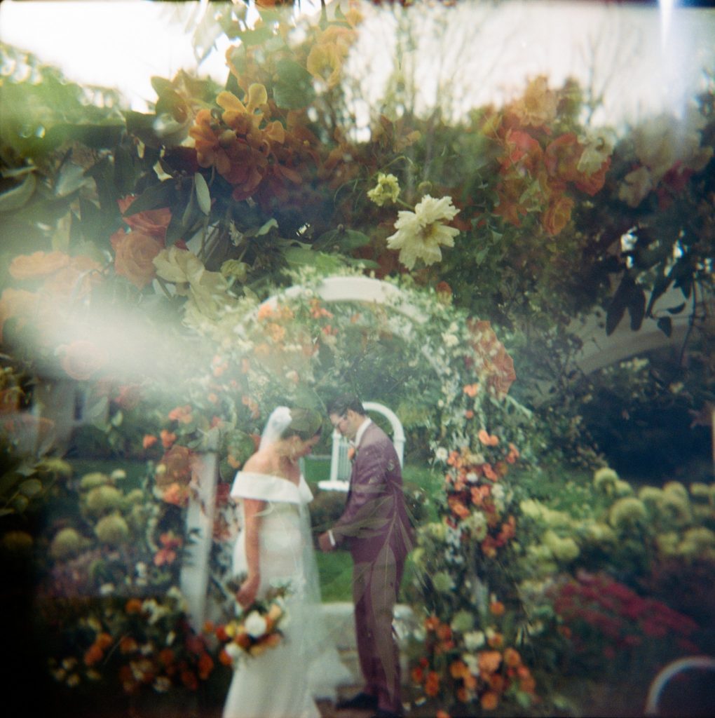 Film photo of modern backyard wedding with abundant flowers; double exposure