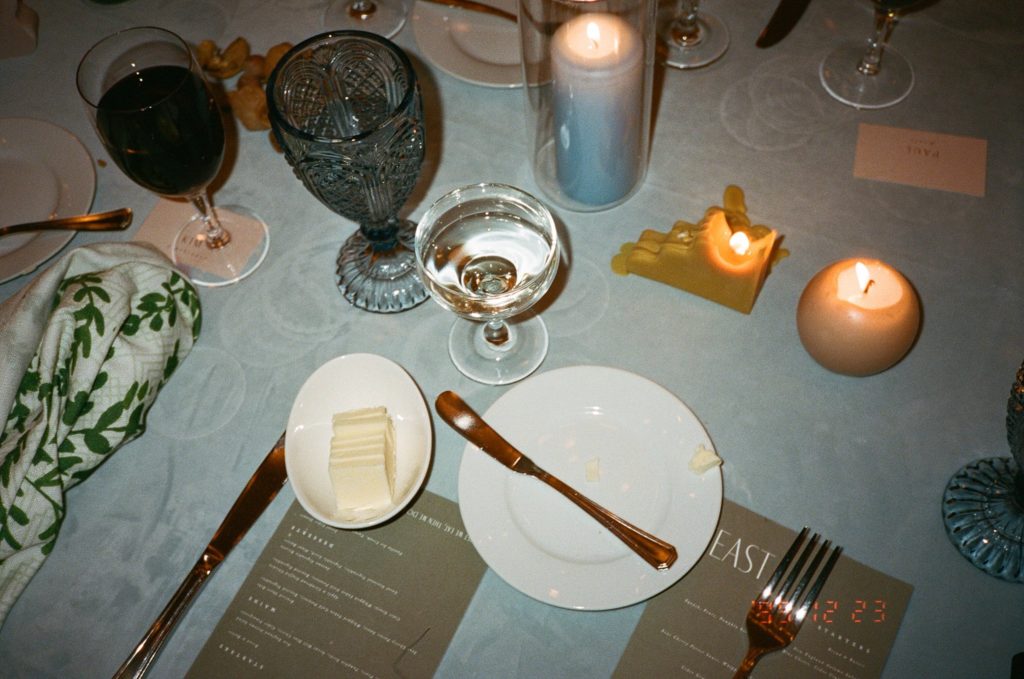 Wedding details including candles, unique glasses, and flatware captured on film