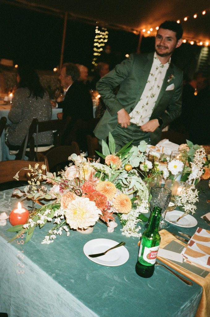 Candid film photograph of a wedding guest posing over floral decorations