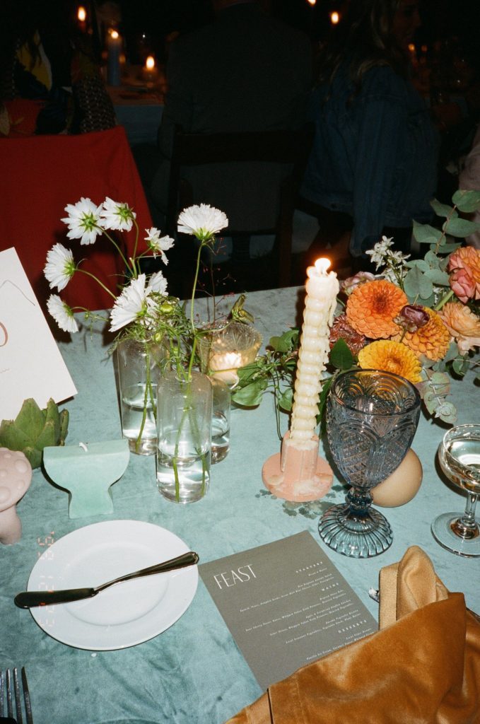 Modern wedding table-setting with candles, wildflowers, vegetables and centerpieces