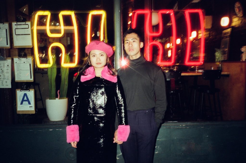 Dramatic neon lights surround a man and woman on a NYC street