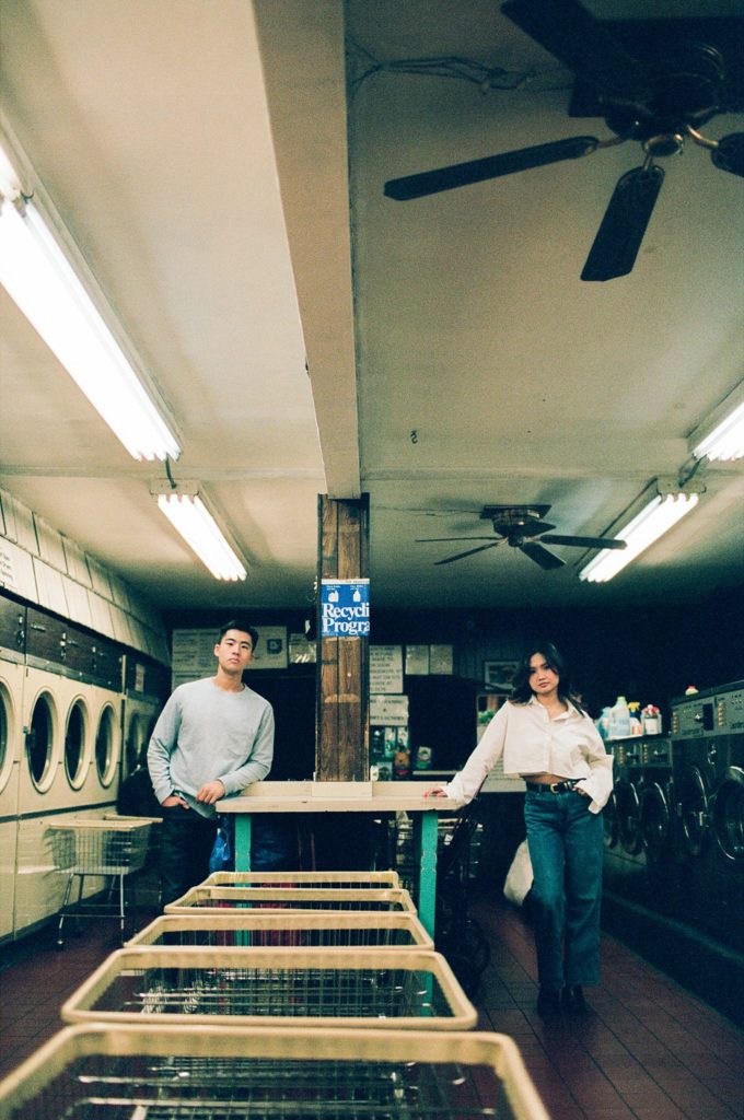 Engaged couple poses in Brooklyn laundromat captured on film