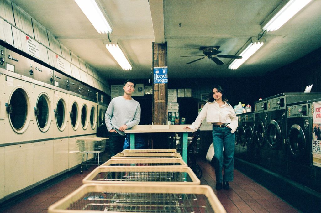 Man and woman pose in vintage Brooklyn laundromat