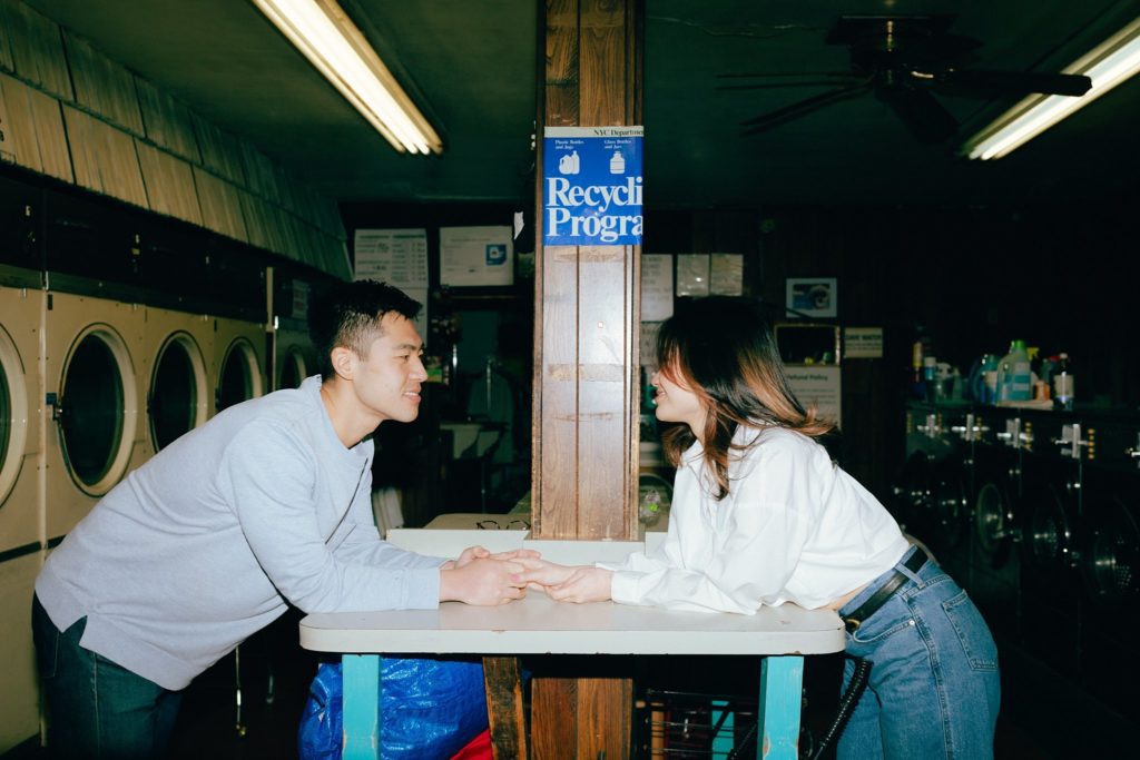 Couple holds hands leaning over opposite sides of a table