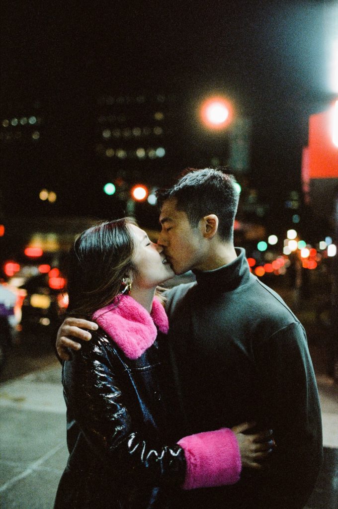 Nighttime film photo of New York City couple kissing on the street