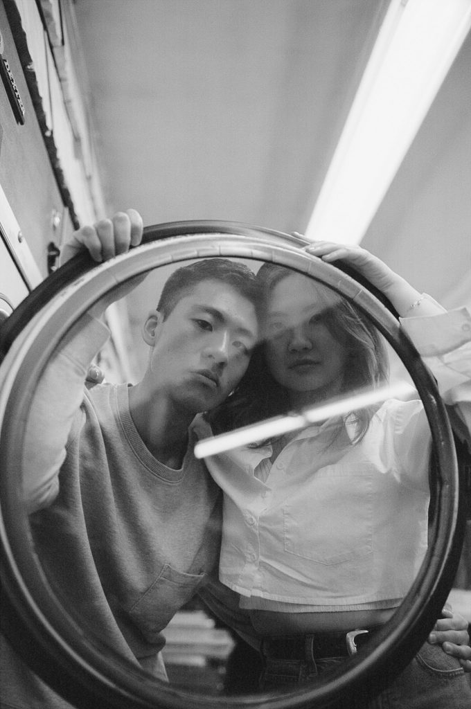 Man and woman look through round glass, black and white film photo
