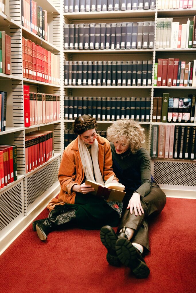 Boston same sex couple browses a book together in a library