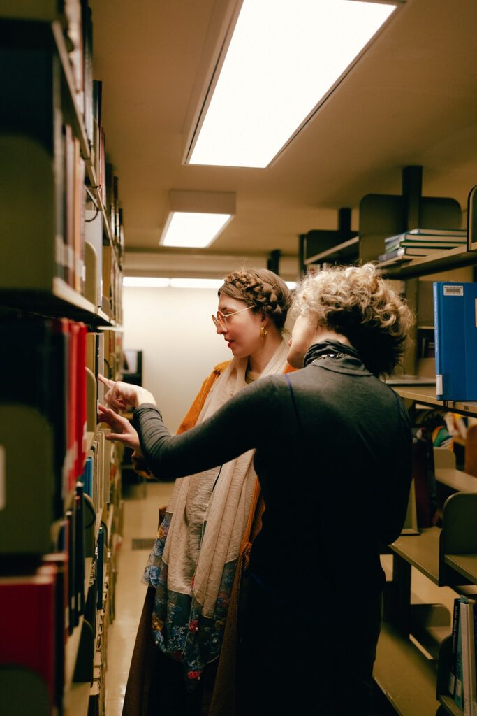 Two woman look at shelves of books, captured on 35mm film