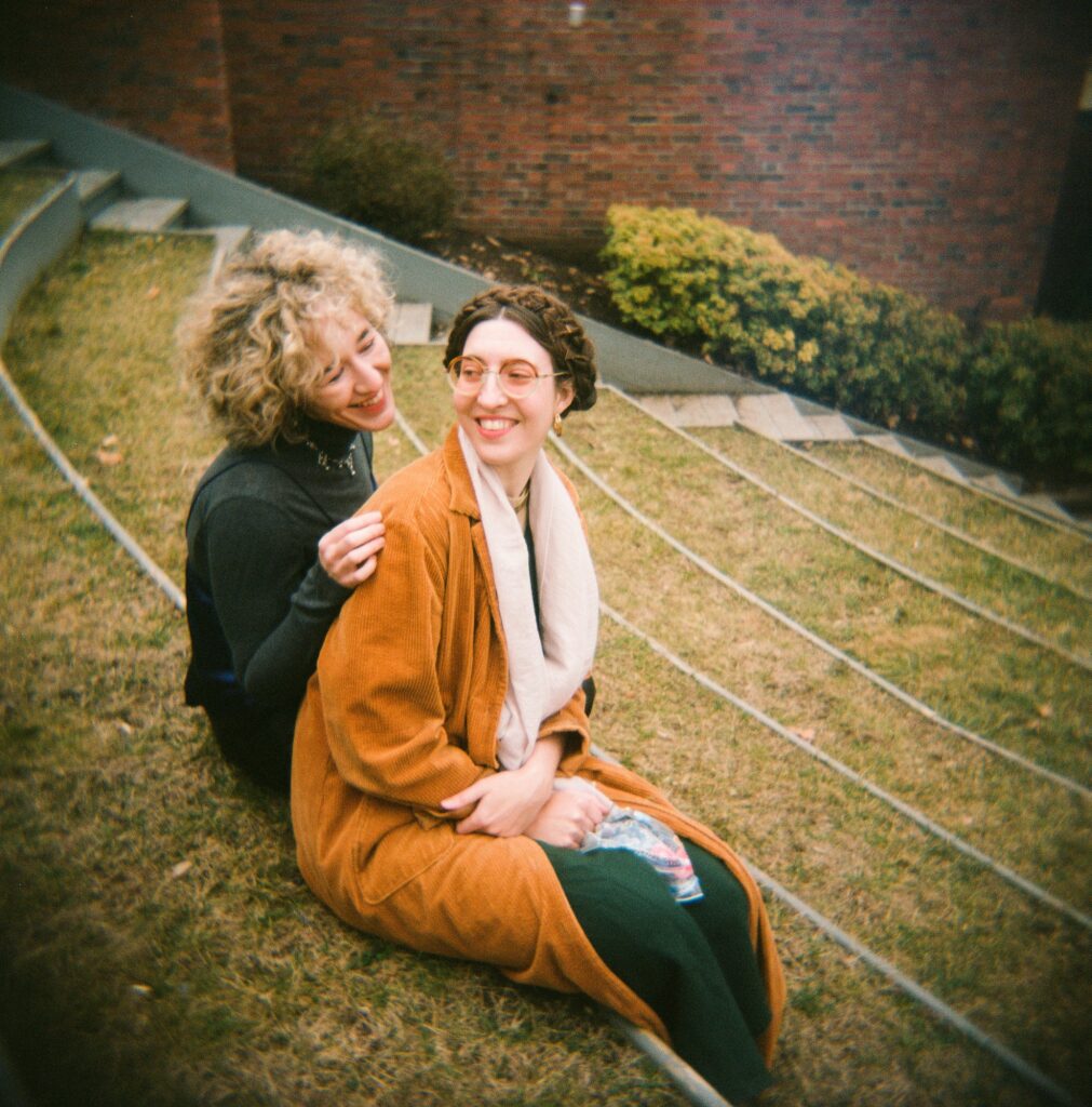 35mm film photo of two women lovingly sitting together outside