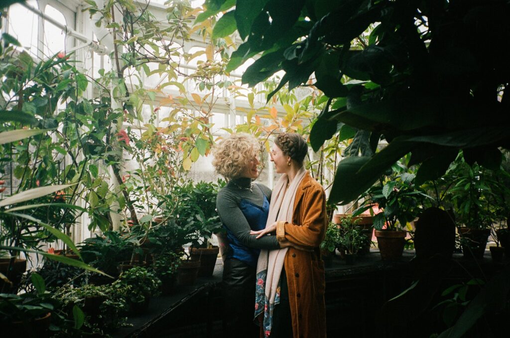 Portrait of engaged couple embracing and smiling among many plants