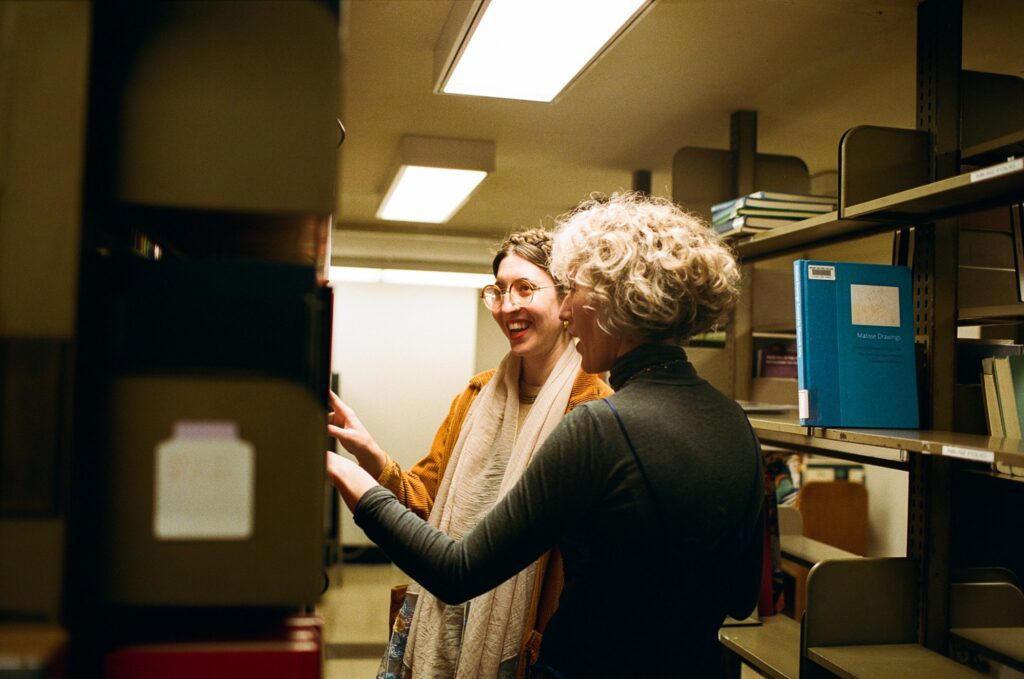 Film photo of two women exploring the archives of a western Massachusetts library