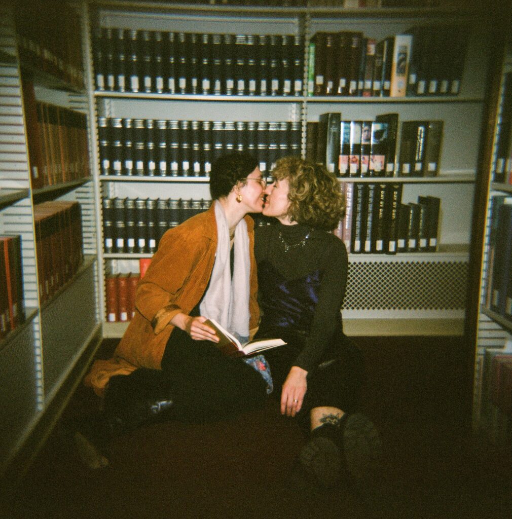 Engaged couple about to kiss in a library, captured on film with direct flash