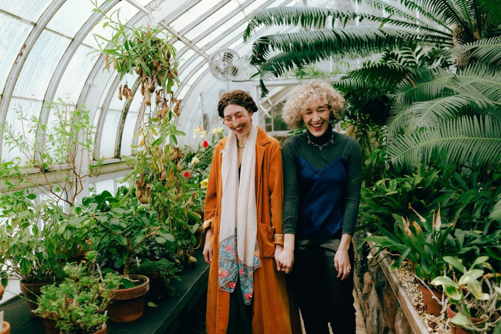 Boston same sax couple holds hands in greenhouse