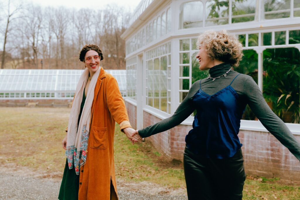 Two women hold hands together outside Berkshires greenhouse
