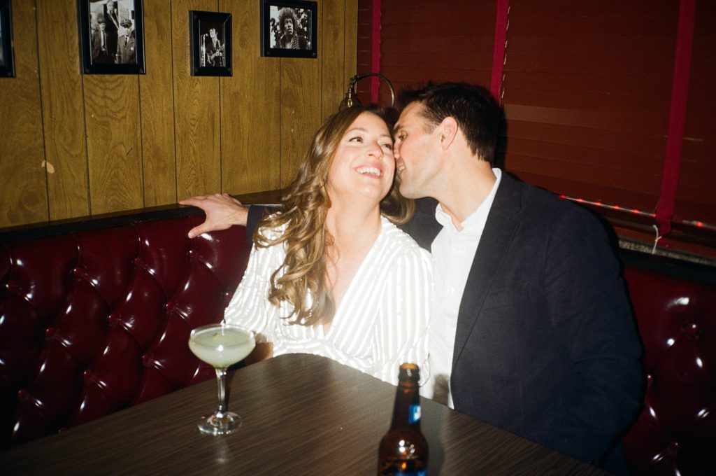 Film photo with direct flash of a couple in a Boston bar