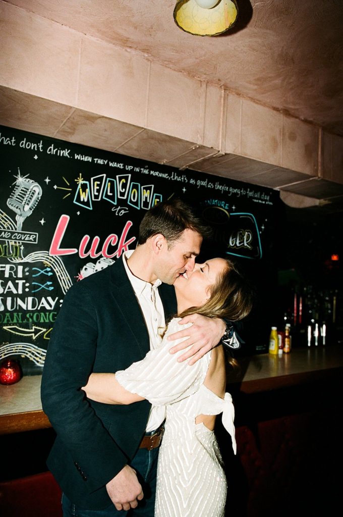 Direct flash photo of engaged couple kissing