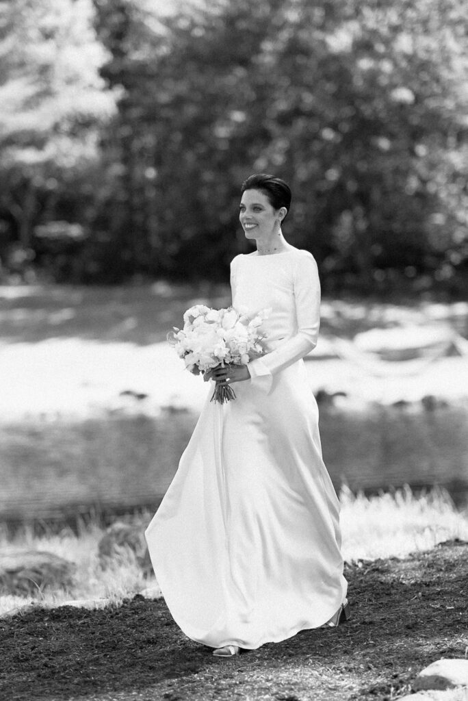Film photo of bride walking with bouquet in black and white