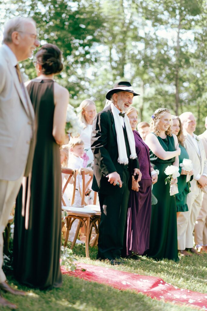 Wedding guests smile as they witness bohemian wedding