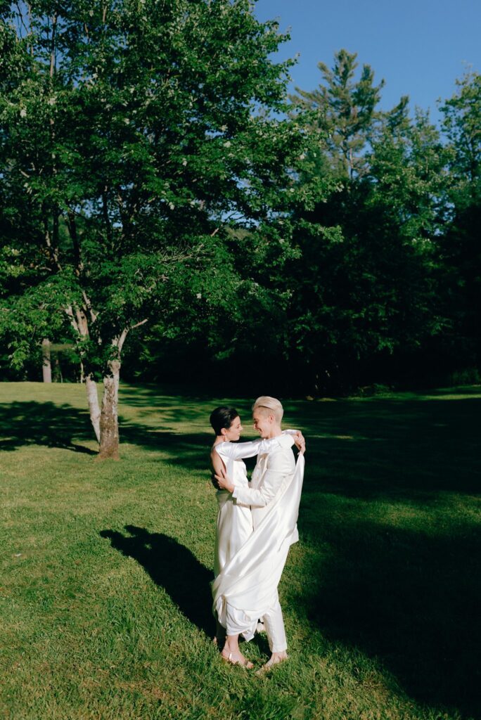 Brides embrace on the grounds of Adirondacks estate