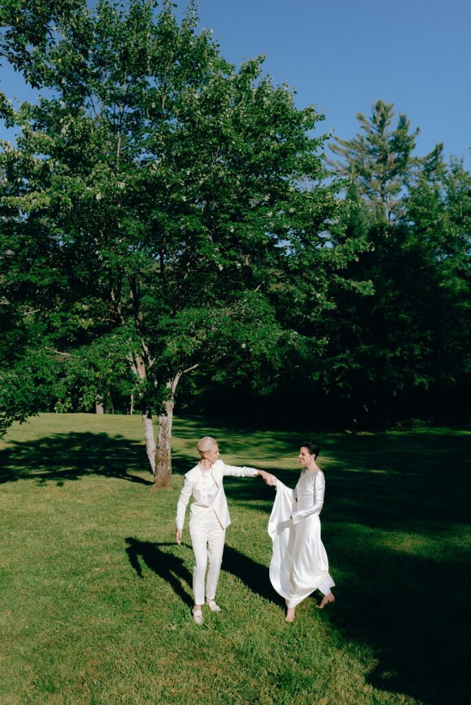 Two women dance and smile together in upstate New York field