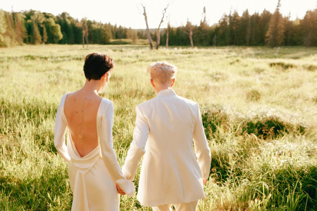Brides walk together across sunlit Adirondacks plains