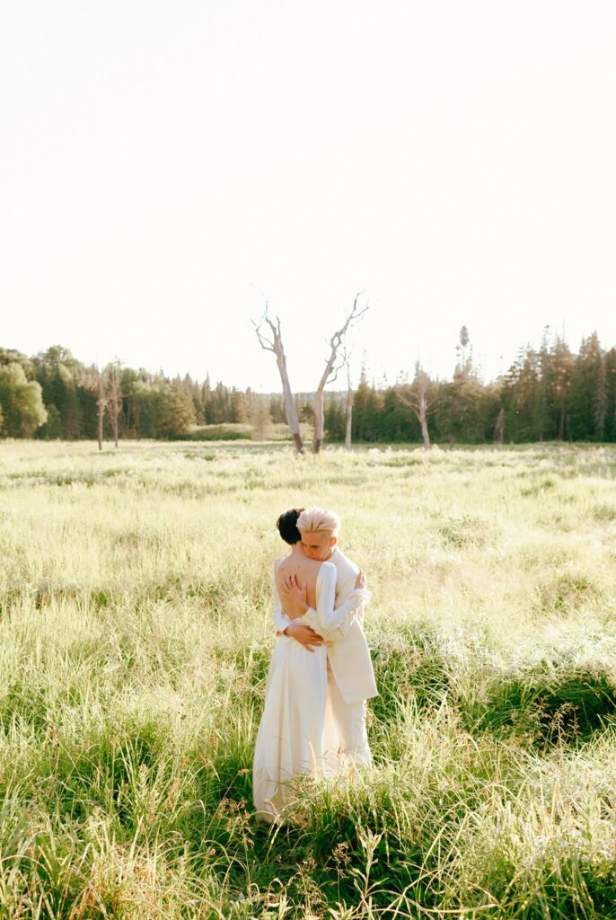 Brides embrace in Adirondacks field