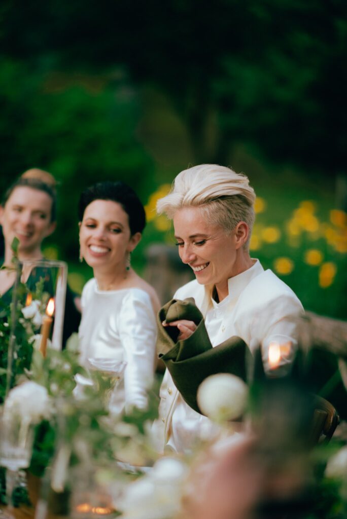 Brides smile seated together at their New York wedding