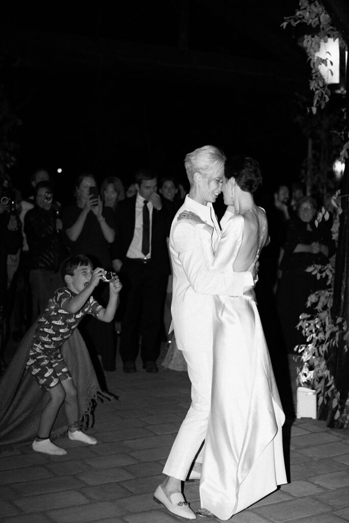 Wedding guests watch two brides dance together
