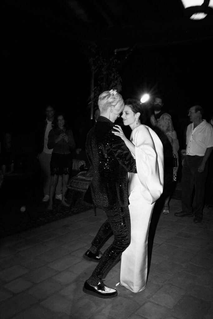 Brides dance together, captured on film in black and white