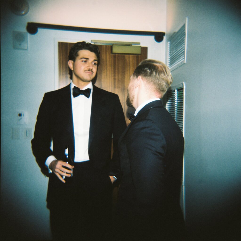 Film photograph of two men talking before wedding at Artists for Humanity