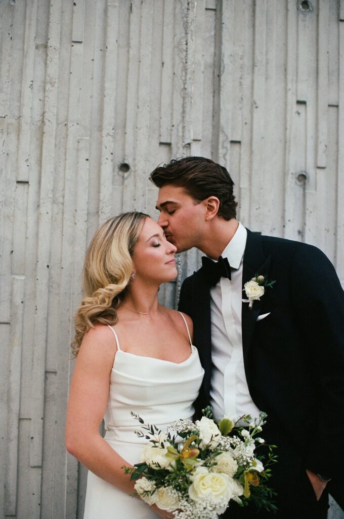 Documentary photo of groom kissing bride