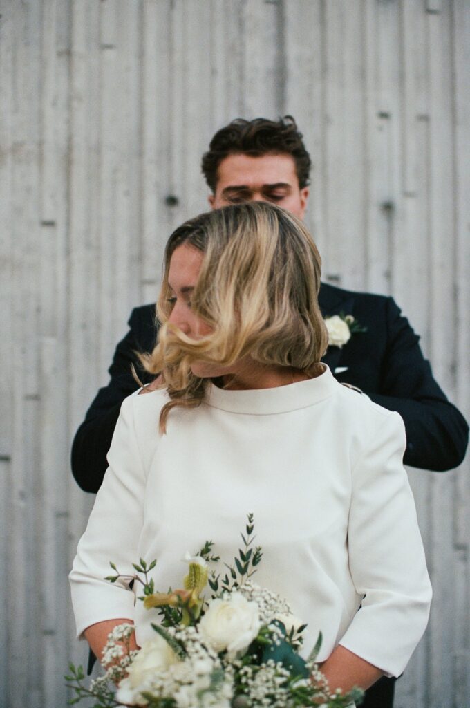 Groom helps bride get ready for wedding, captured on film
