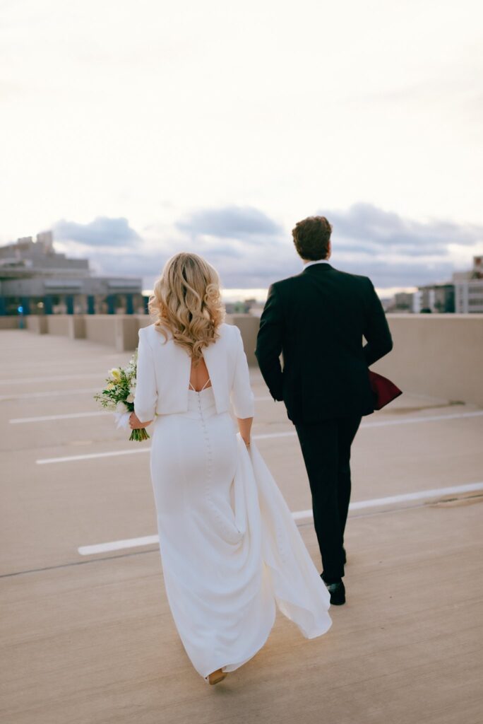 Bride and Groom walk together across a Boston rooftop