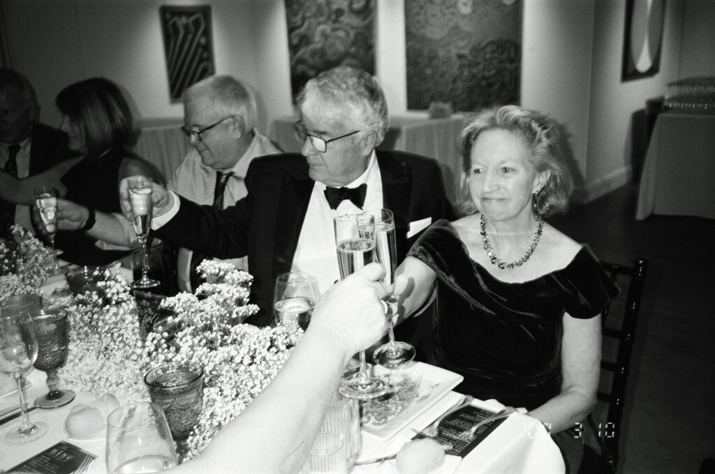 Film photograph in black and white of wedding class toasting