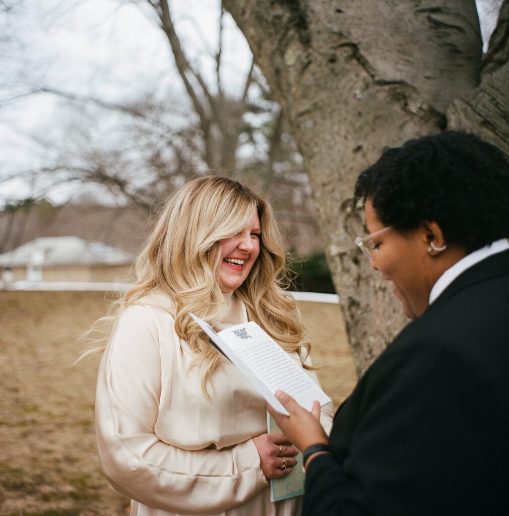 Two brides stand beneath a majestic tree, their heartfelt vows whispered in the breeze
