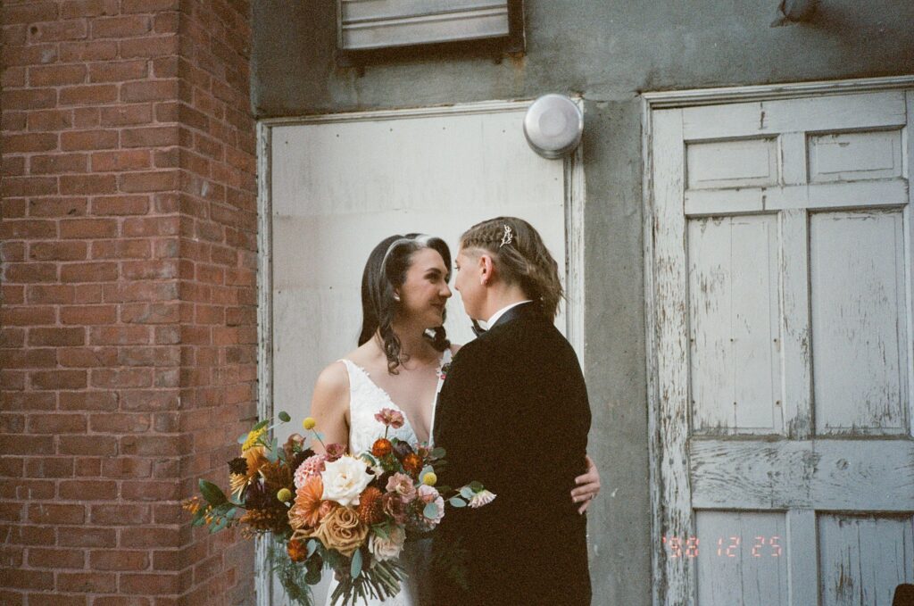 two brides look at each other on a portrait on film
