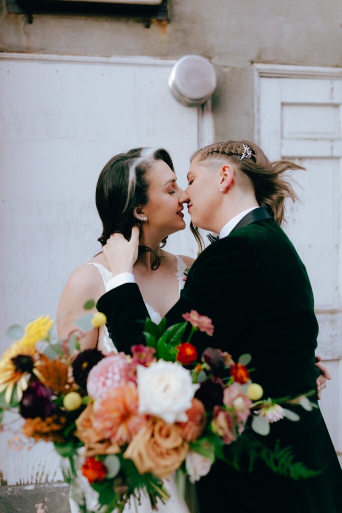 two brides lean in for a kiss on their wedding day
