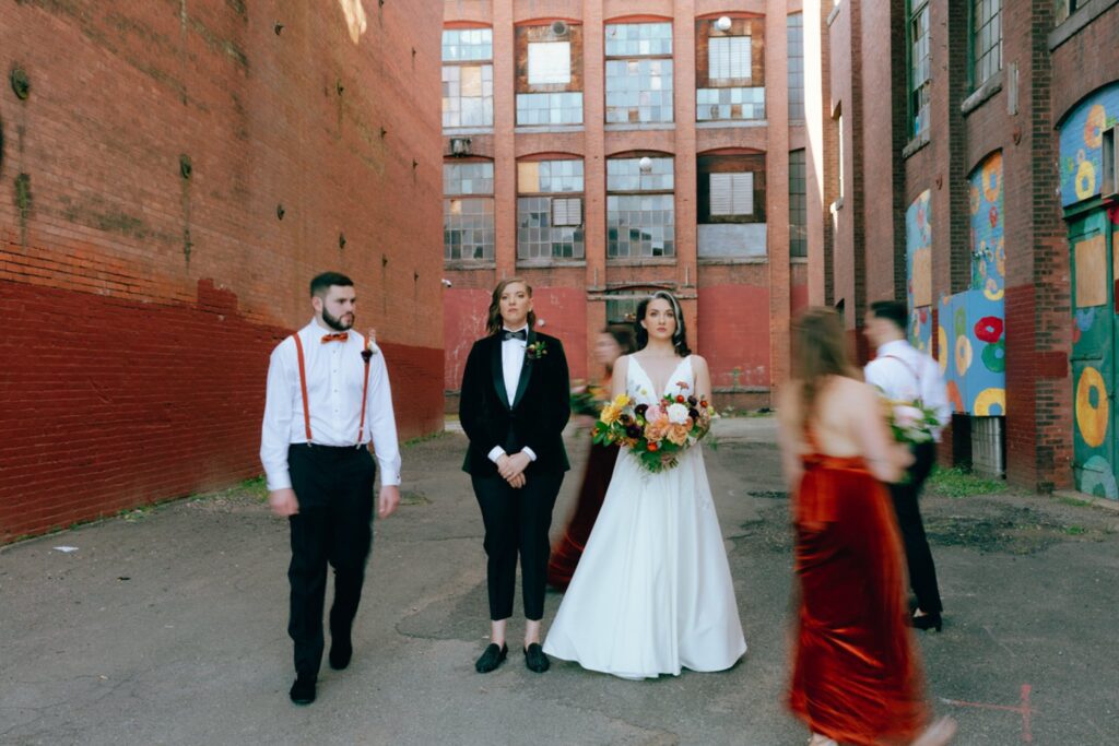 a wedding party walks around two brides