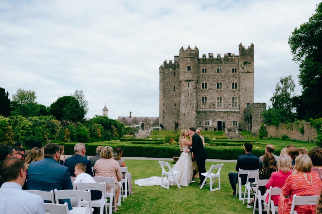 a couple shares their first kiss in front of Kilkea Castle