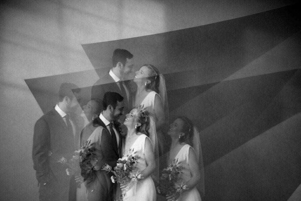 Artistic black and white photograph of bride and groom shot through a prism